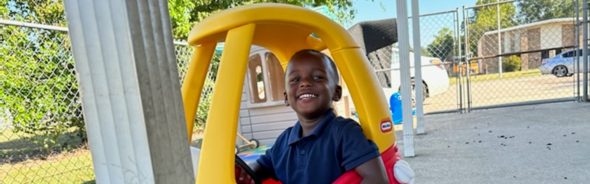 child in a toy car